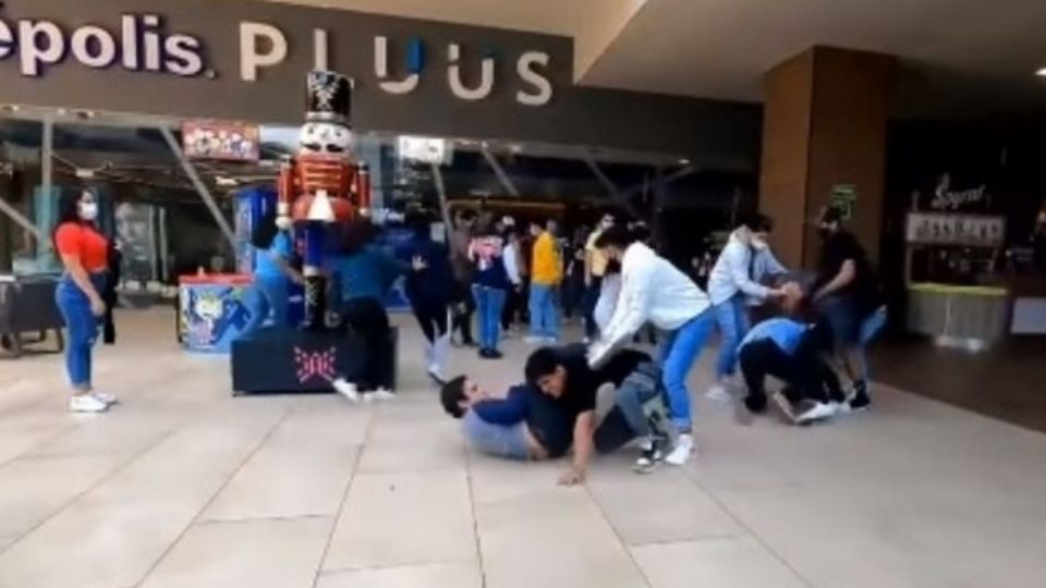 Varios jovencitos se enfrascan en una riña en plena entrada de cine.