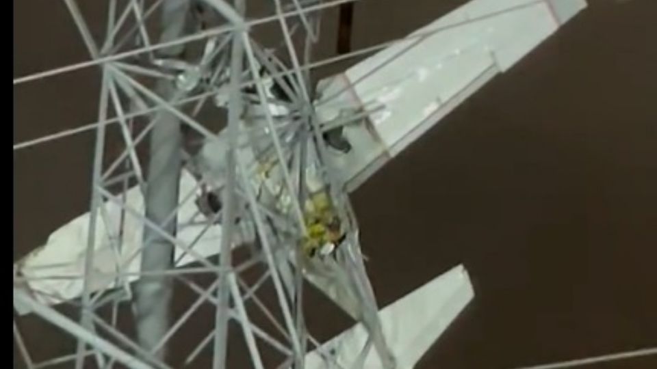 La avioneta quedó atorada en la torre eléctrica.