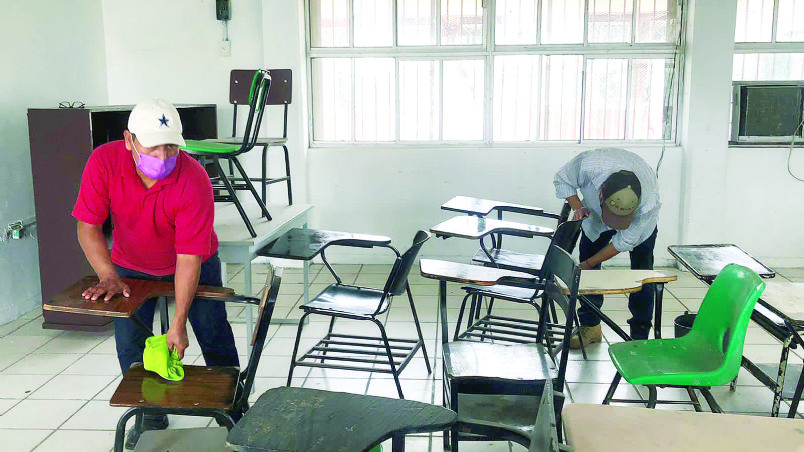 Padres de familia y maestros trabajan en la limpieza de la escuela.