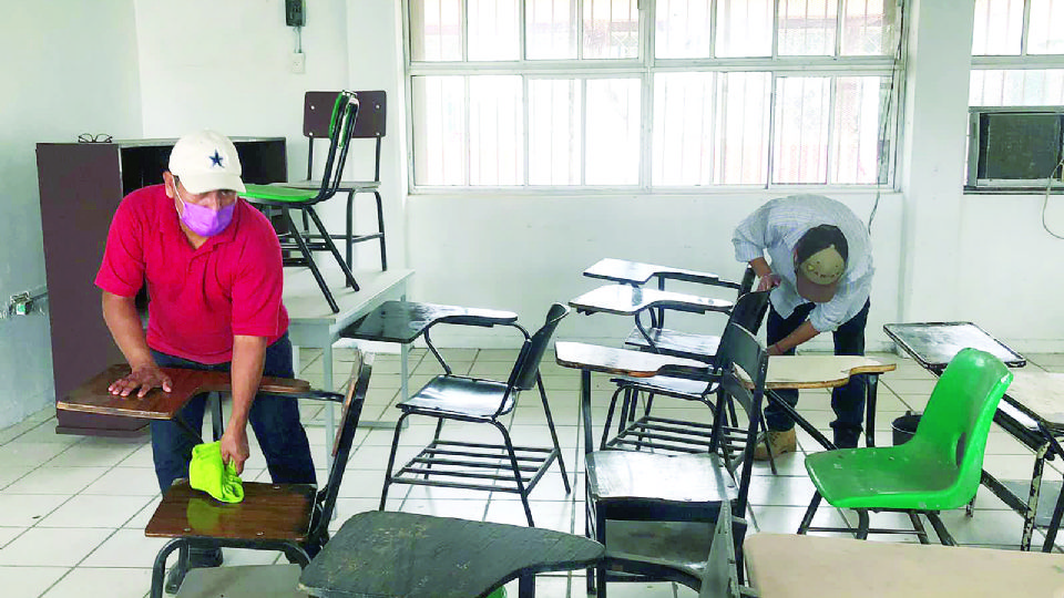 Padres de familia y maestros trabajan en la limpieza de la escuela.