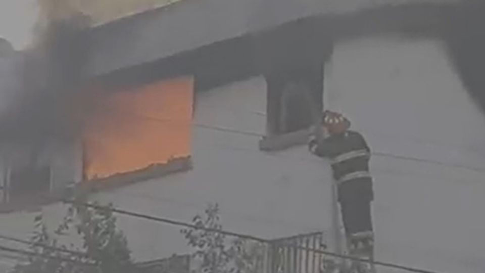 Un bombero se acerca a la ventana de un departamento para rescatar a un hombre