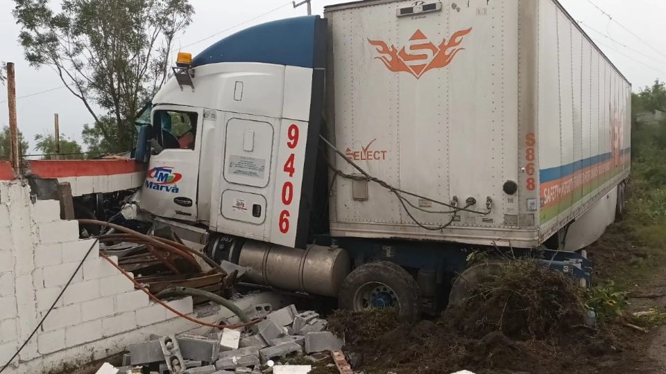 El presunto cruce de un auto particular causó que el transportista perdiera el control de su unidad, yéndose a estampar a una barda