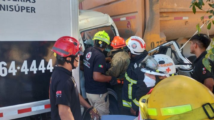 Chocan camiones de carga; hay dos hombres prensados