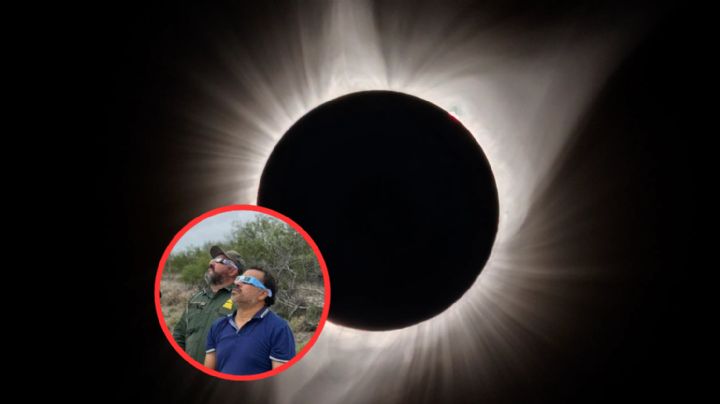 Migrantes esposados y en custodia se detienen para ver el eclipse solar en frontera de EU y México