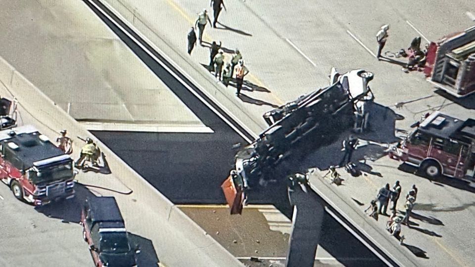 Las autoridades auxiliaron al conductor de un trailer que quedó suspendido desde un puente tras volcar